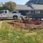 StumpBusters truck, dump trailer, and Barreto stump grinder at work on a residential stump removal job in Central Pennsylvania. In the middle of stump grinding cleanup.